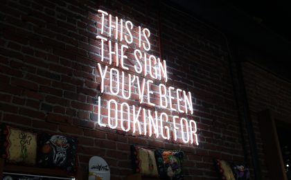 Glowing Neon sign that says " This is the sign you've been looking for" .